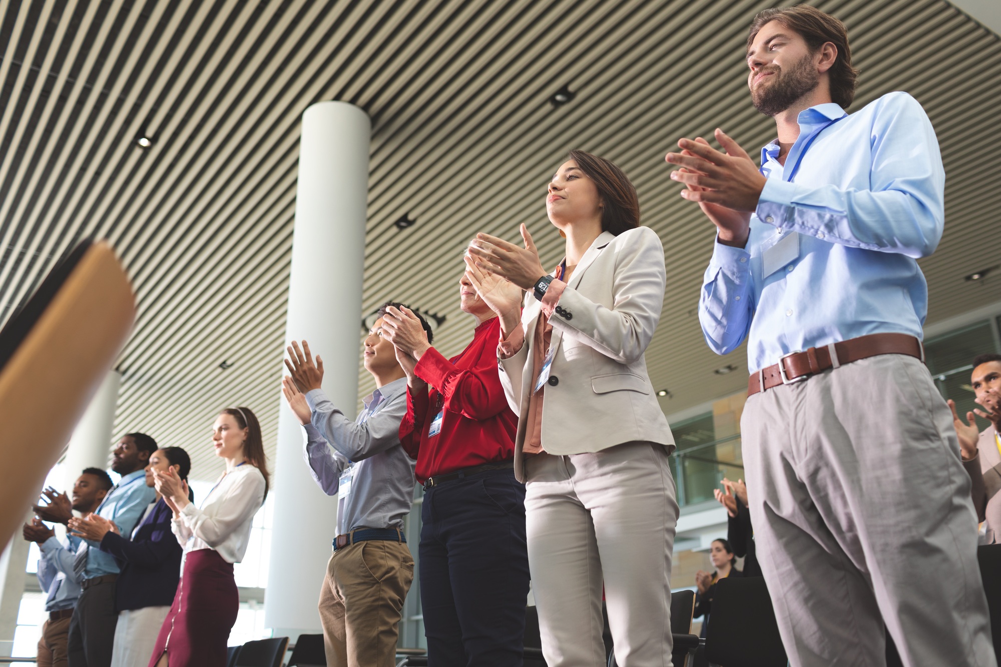 Business people clapping while standing at a business seminar in office