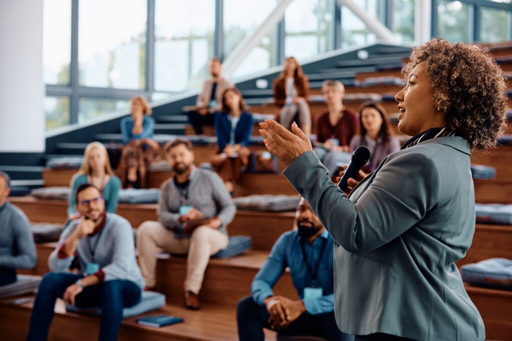 Female speaker talking on a business conference at convention center. Motivational Speaker